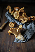 Fresh chanterelle mushrooms on a cloth and on a wooden table
