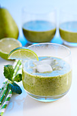 Glasses of green smoothies with pear, banana and spinach
