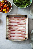 Bacon slices on an aluminum baking pan