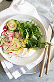 Frühlingssalat mit Radieschen, Gurken und blühendem Rucola