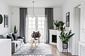 Corner fireplace and plants in classic living room in grey and white