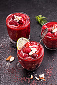 Blended strawberry shake smoothie with whole strawberries, ice and lemon in glasses