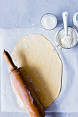 Yeast dough being rolled out with a rolling pin