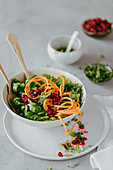 Lambs lettuce with carrot noodles and pomegranate seeds