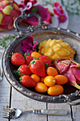 Strawberries, kumquats and dragon fruit in a elegant fruit bowl