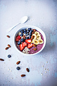 A berry smoothie bowl with banana and almonds