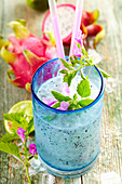 Cocktail mit Drachenfrucht, Limettensaft, Pitu Cachaca, Mandelsirup und Blüten
