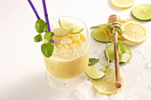 Mango-Reis-Shake mit Limetten und Honig im Glas mit Trinkhalm