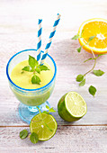 Creamy pineapple and coconut smoothie with coconut milk, lime, orange and ginger