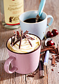 Black Forest coffee with whipped cream, kirsch, vanilla and chocolate chips in a pink enamel cup