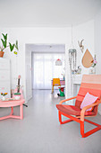 Coffeetable und Sessel als rosa-rote Farbakzente in weißem lichtdurchflutetem Wohnraum