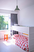 White bunk beds in light-flooded children's bedroom