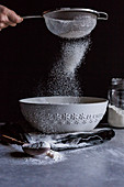 Sifting flour into a bowl