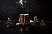 Christmas cake being dusted with icing sugar