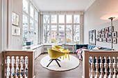 Yellow armchairs and blue sofa in living room with balustrade