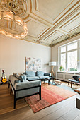 Blue sofas in living room with stucco ceiling in Wilhelmine-era villa