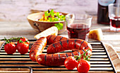 Grilled chorizos with salad, cherry tomatoes and baguette (Argentina)