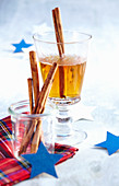 A glass of hot winter whiskey with cinnamon sticks, almonds and apple juice for Christmas