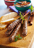 Oriental grilled minced meat kebabs with cinnamon, a spicy tomato salad and unleavened bread