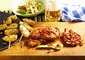 Grilled, marinated pork collar steaks with potato skewers and fennel salad (USA)