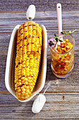 Marinated, grilled corn cobs with a pepper salsa