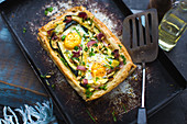 Puff pastry tart with vegetables, egg and pine nuts