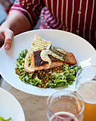 Green salad with peas, roasted salmon and grilled baguette.
