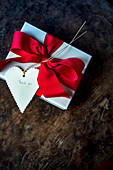 Gift wrapped with red bow and 'Thank you' written on heart-shaped tag