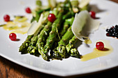 Green asparagus with red currants and parmesan