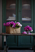 Pink roses in basket and metal vase