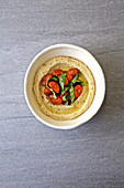 Hummus mit getrockneten Tomaten und Basilikum als Topping