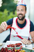 Mid adult man holding crayfish, Stockholm, Sweden