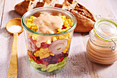 American layered salad with a yoghurt dressing in a glass