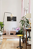 Sofa bed, standard lamp and wooden console table used as desk in foreground