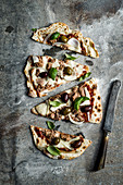 Fladenbrotpizza mit Thunfisch, Oliven, Zwiebeln, Basilikum und Mozzarella