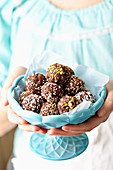A woman holding a bowl of homemade truffle chocolates