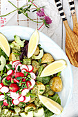 Vegetable salad with potatoes, radishes, pesto and lemons