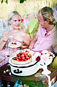 Paar isst Erdbeertarte beim Picknick