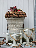 Wreath of walnuts on stone urn and candle lanterns