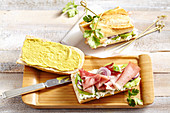 Baguette sandwich with kiwi, cottage cheese, smoked ham, coriander leaves and onion