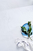 Place setting with blue and white plate, twigs and tea towel