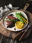 Ostrich medallions with a potato cake and beans