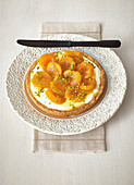 A mini sour cream tart with apricot compote and pistachio nuts