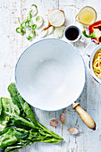 Enamel wok and ingredients for vegetarian pasta dish