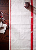 Laid table with a tea towel, red wine and a cloth napkin