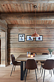 Modern upholstered chairs around dining table in modern log cabin