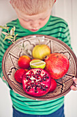 Boy holding bowl with fruits