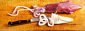 Raw squid (calamari) and a kitchen knife