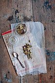 Cardamom on translucent baking parchment and newspaper
