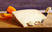 Pecorino sardo, hard cheese made from sheep's milk (Sardinia) on a wooden board with a knife